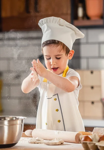 stock image cute little boy working with dough at the kitchen