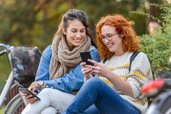 Дві Молоді Жінки Сидять Лавці Використовують Смартфон — стокове фото
