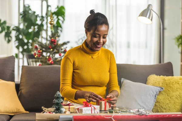 Stock image african american woman preparing for holidays, wrapping gifts