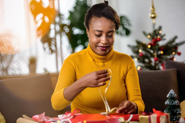 Stock image african american woman preparing for holidays, wrapping gifts