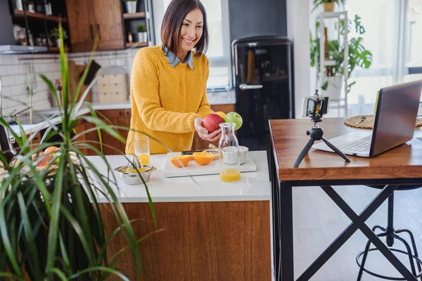 stock image Young woman making a vlog about healthy food and drinks at her home using mobile phone