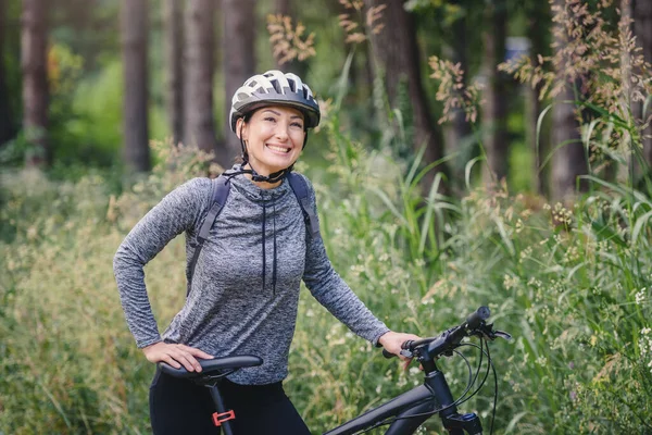 a young woman riding on a bicycle in forest