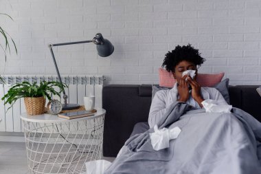 Yatakta grip olan Afrikalı bir kadın.