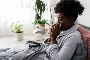 Yatakta grip olan Afrikalı bir kadın.