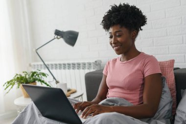 Afrikalı-Amerikalı kadın dizüstü bilgisayarda yazarak 