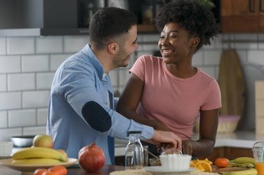 Genç çift mutfakta kahvaltı yapıyor. 