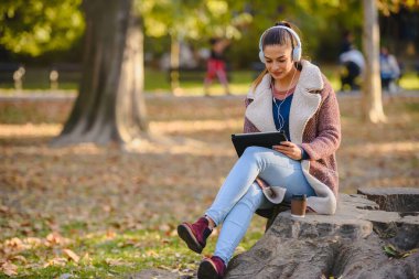 Parkta tablet kullanan güzel kadın.