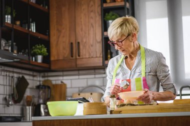 Kurabiye için hamur yapan güzel son sınıf kadını.