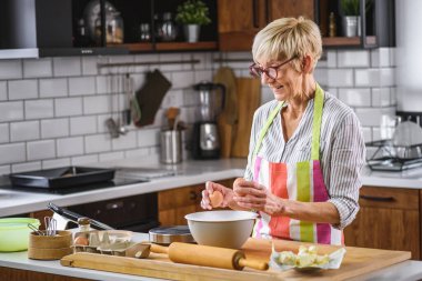 Kurabiye için hamur yapan güzel son sınıf kadını.