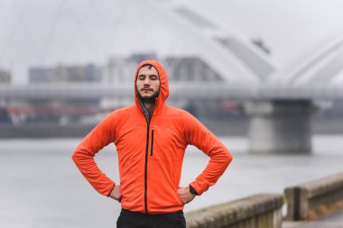 Genç adam şehirde koşuyor. 