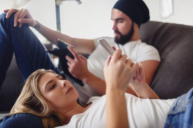 Çift oturma odasında dinleniyor, aletler kullanıyor.