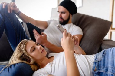 Çift oturma odasında dinleniyor, aletler kullanıyor.