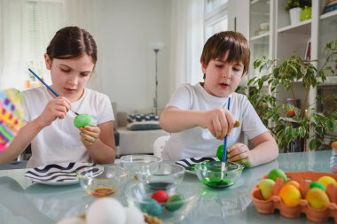 Erkek ve kız kardeş yumurta boyamaya hazırlanıyor.