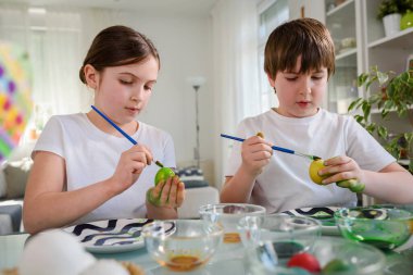 Erkek ve kız kardeş yumurta boyamaya hazırlanıyor.