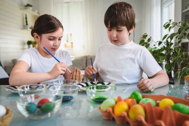Erkek ve kız kardeş yumurta boyamaya hazırlanıyor.