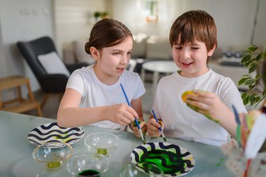 Erkek ve kız kardeş yumurta boyamaya hazırlanıyor.