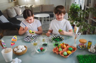 Erkek ve kız kardeş yumurta boyamaya hazırlanıyor.