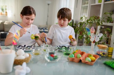 Erkek ve kız kardeş yumurta boyamaya hazırlanıyor.