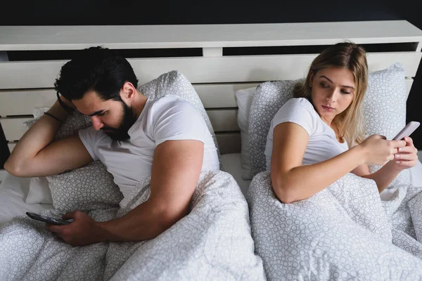 Young Couple Lying Bed Using Mobile Phones — Stock Photo, Image