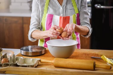 Yaşlı kadın ev mutfağında yemek pişiriyor.. 