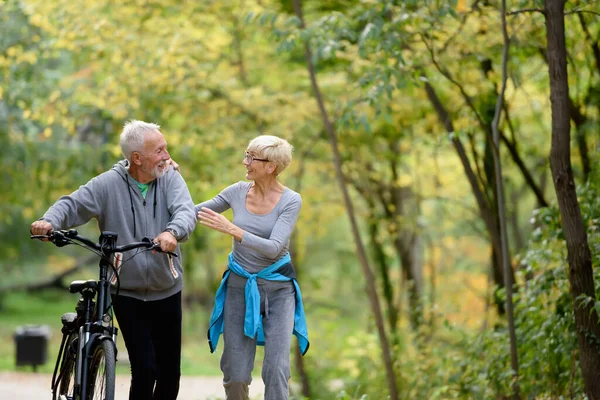 Fröhliches Rühriges Seniorenpaar Mit Fahrrad Spaziert Gemeinsam Durch Den Park — Stockfoto