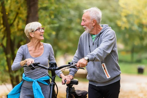 Fröhliches Rühriges Seniorenpaar Mit Fahrrad Spaziert Gemeinsam Durch Den Park — Stockfoto