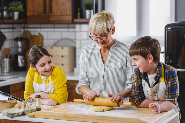 孫と孫娘とクッキーを作るおばあちゃん — ストック写真