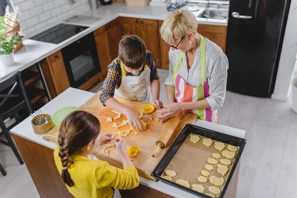 孫と孫娘とクッキーを作るおばあちゃん — ストック写真