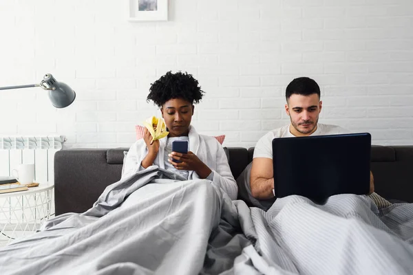 Young Multiracial Couple Using Mobile Electronic Devices Bed Ignoring Each — Stock Photo, Image