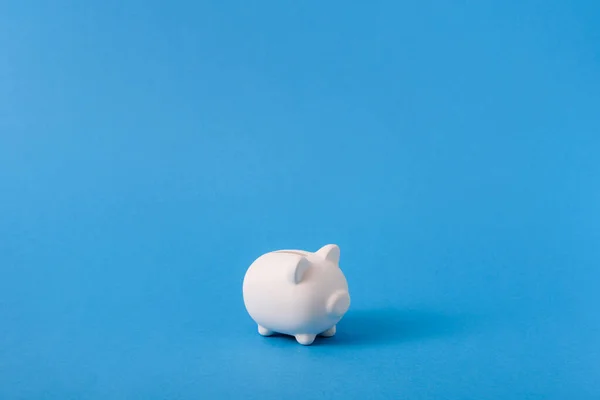 stock image White piggy bank on blue color background. Saving, money accumulation, investment, banking or business services, wealth concept. Copy space advertising mock up