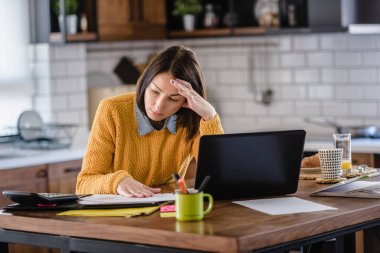Serbest çalışan kadın projeyle ilgili sorunları olduğu için üzgün. Hüsrana uğramış endişeli kadın kötü haberden dolayı üzgün bir şekilde dizüstü bilgisayara bakar..