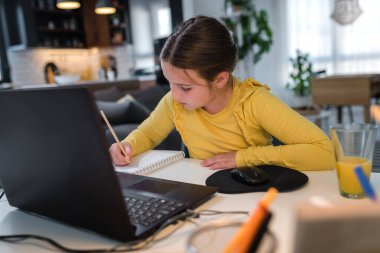 Kız öğrenim görürken bilgisayarını kullanıyor, online eğitim.