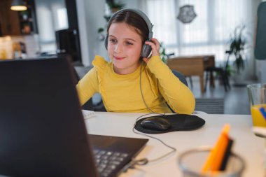 Kız öğrenim görürken bilgisayarını kullanıyor, online eğitim.