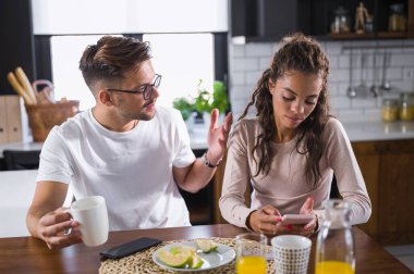 Sabahları mutfakta genç bir çift ilişki sorunları yaşıyor. Tartışma.