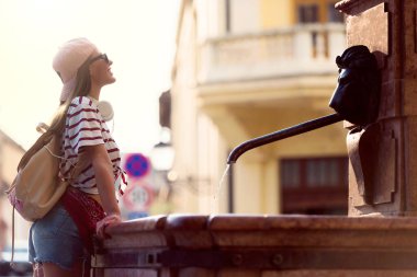 Çeşmenin yanında güzel genç bir kadın