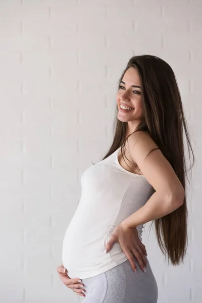 Genç Güzel Hamile Bir Kadın Tuğla Duvarın Üzerinde Duruyor — Stok fotoğraf