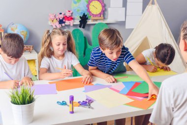 Çocuklar okulda öğretmenleriyle el sanatları yapıyor.