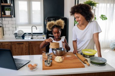 Şirin Afro-Amerikan anne ve kızı evde kurabiye pişiriyor. 