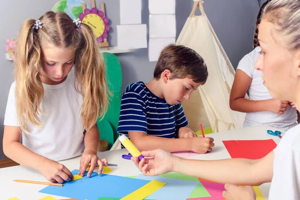 幼稚園の先生と紙細工を作る子供たち — ストック写真