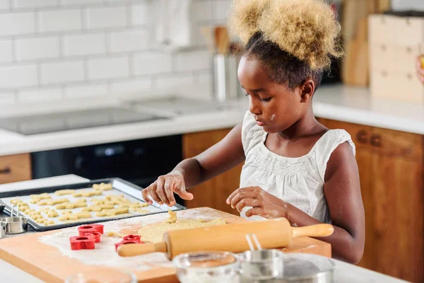 stock image little cute african-american kid baking cookies in kitchen at home, close-up