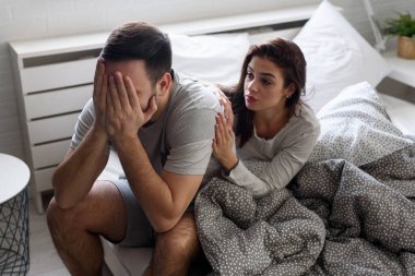 Üzgün genç çift yatak odasında kavga üstüne kavga ediyor.