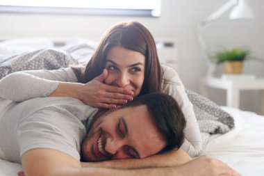 Genç çift yatakta yatıyor. 