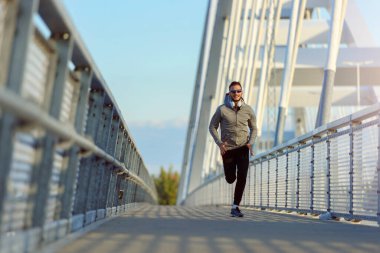 Genç formda bir fitness adamı şehir caddesinde koşuyor. sağlıklı yaşam tarzı 