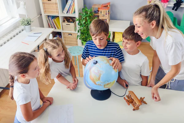 stock image group of children and teacher in classroom learning geography