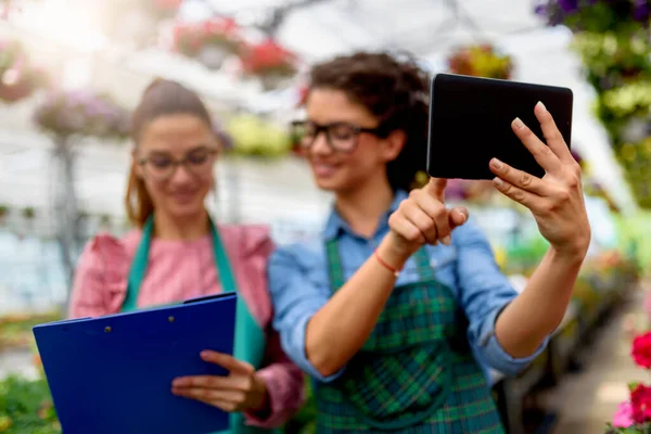 stock image young women using tablet in greenhouse 