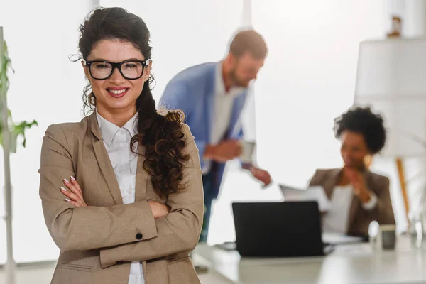 stock image portrait of beautiful young businesswoman in the office, colleagues on background