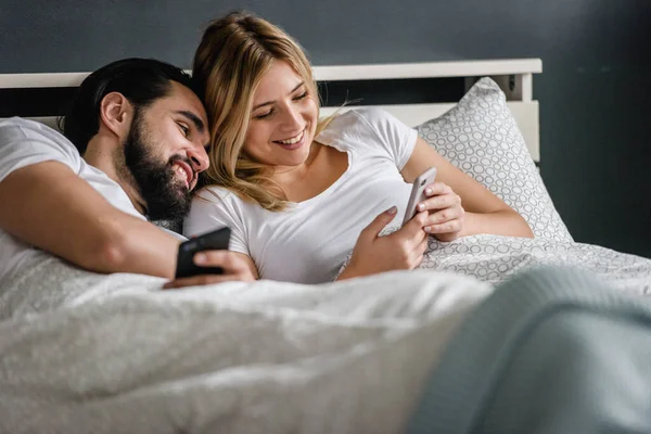 Gelukkig Paar Liggend Bed Kijken Naar Smartphone Ochtend — Stockfoto