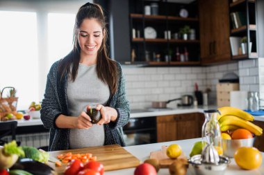 Kadın mutfakta sebze ve meyve kesiyor, sağlıklı gıda konsepti. 