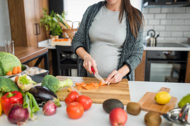 Kadın mutfakta sebze ve meyve kesiyor, sağlıklı gıda konsepti. 