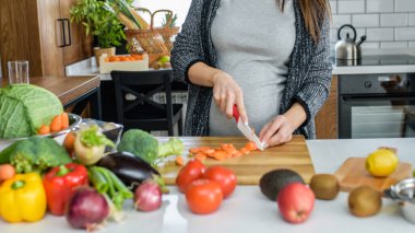 Kadın mutfakta sebze ve meyve kesiyor, sağlıklı gıda konsepti. 